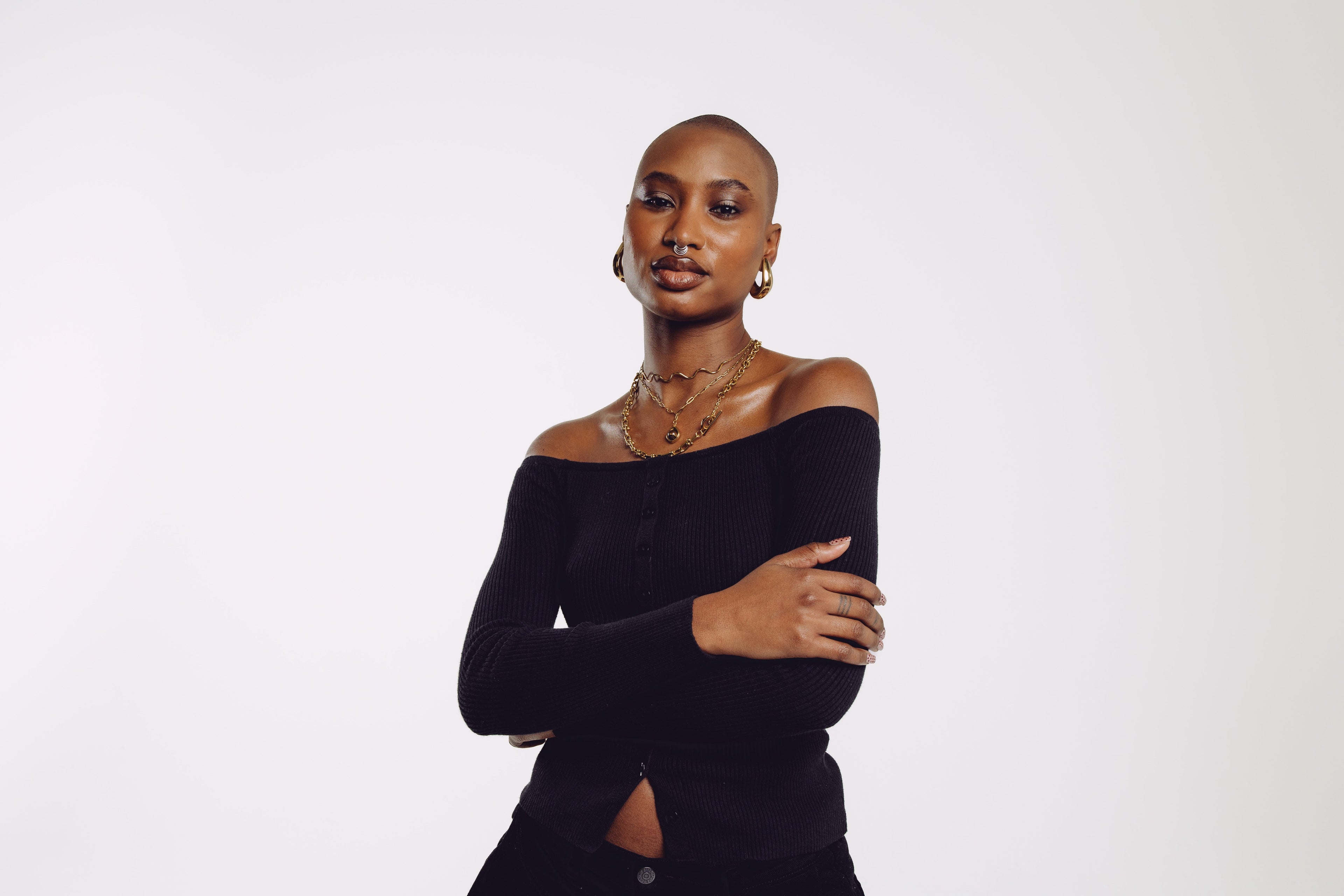 Model wearing the Muse gold necklace stack — three pre-set layered gold necklaces styled for everyday wear | STXCKD