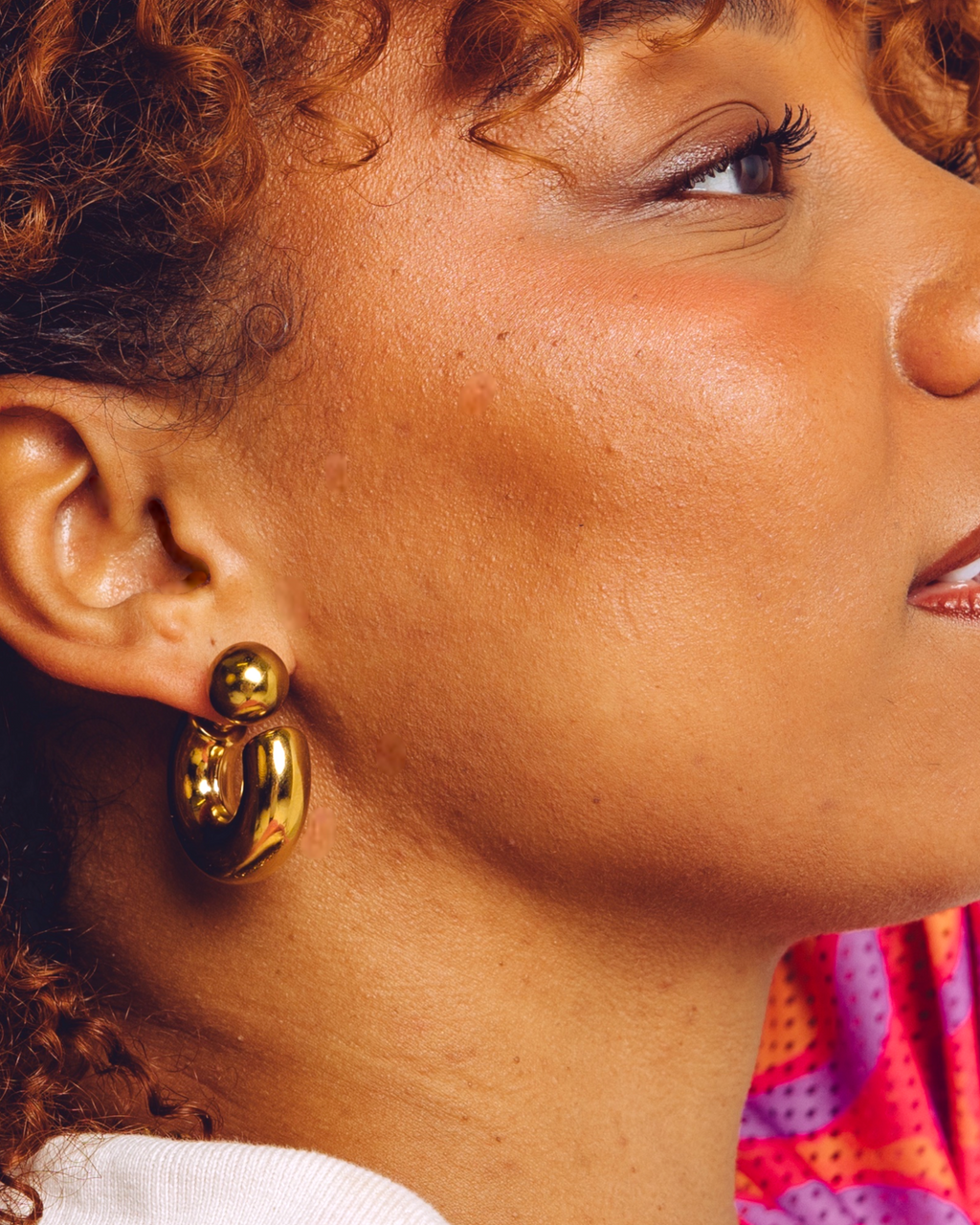 Arc chunky gold hoop earrings worn by model — bold statement earrings by STXCKD